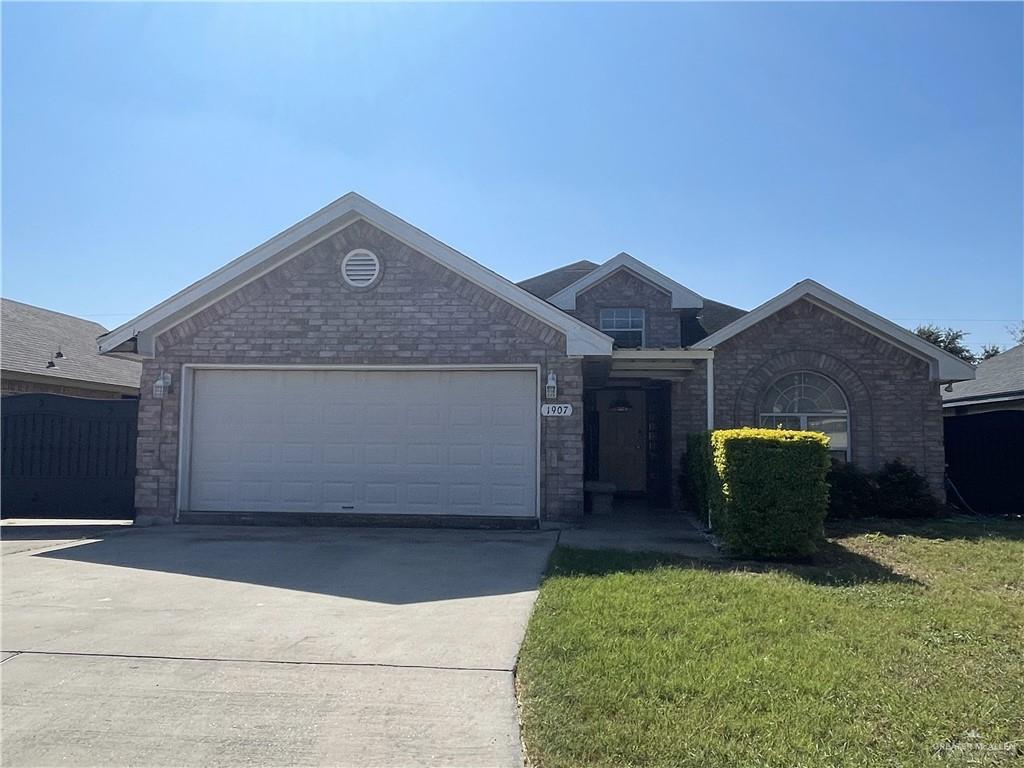 View of front of home with a garage and a front lawn