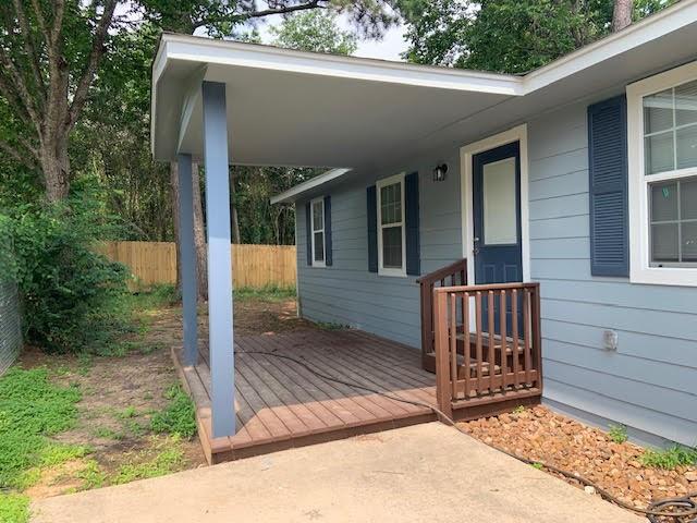 a view of a house with a small yard and wooden floor and fence