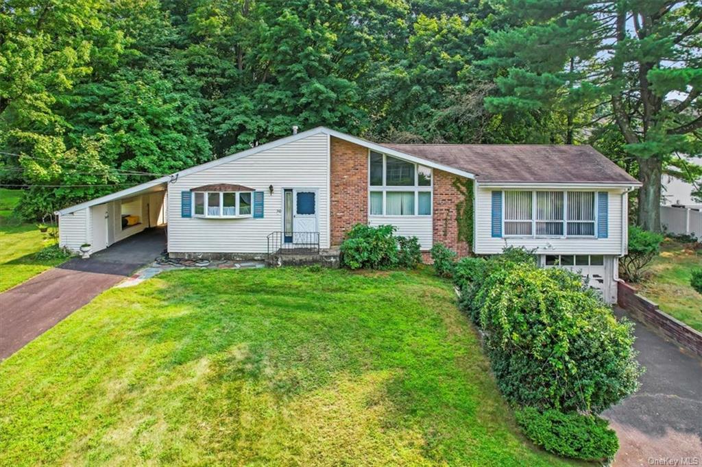 Single story home featuring a carport and a front yard