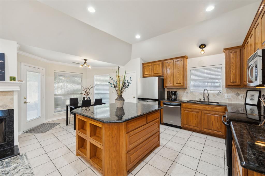 a kitchen with stainless steel appliances granite countertop a sink and a refrigerator