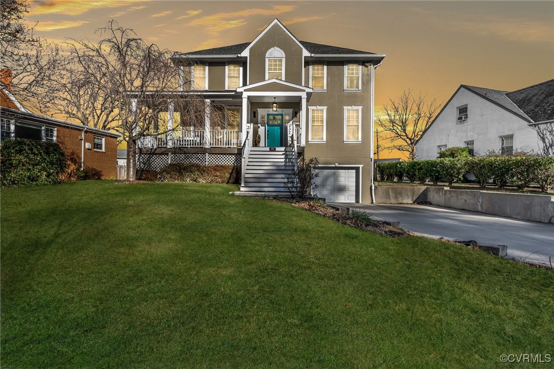 View of front facade featuring a yard and a garage