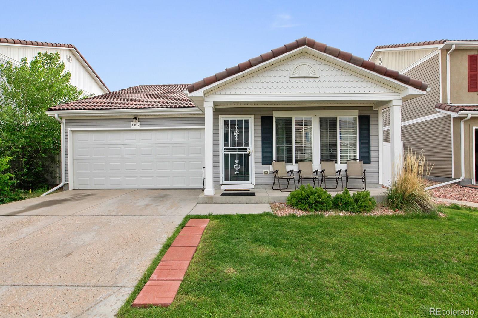 a front view of a house with a garden and plants