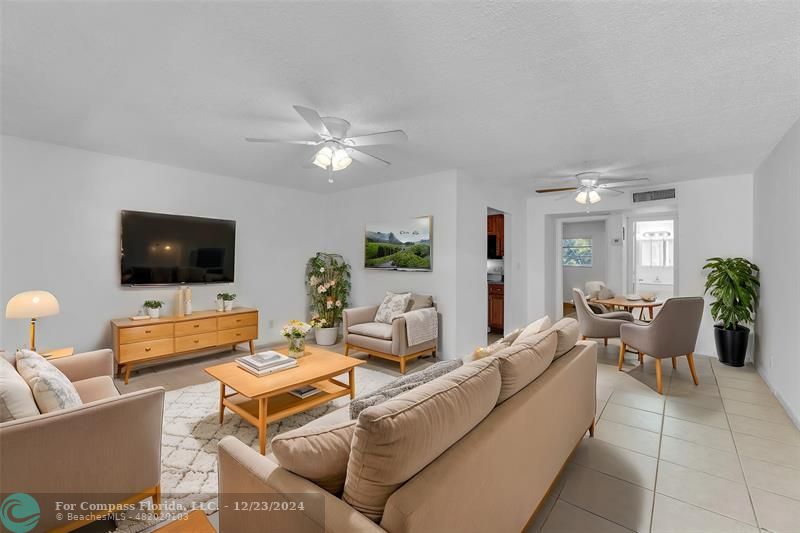 Large and spacious living room with tile flooring and overhead ceiling fans