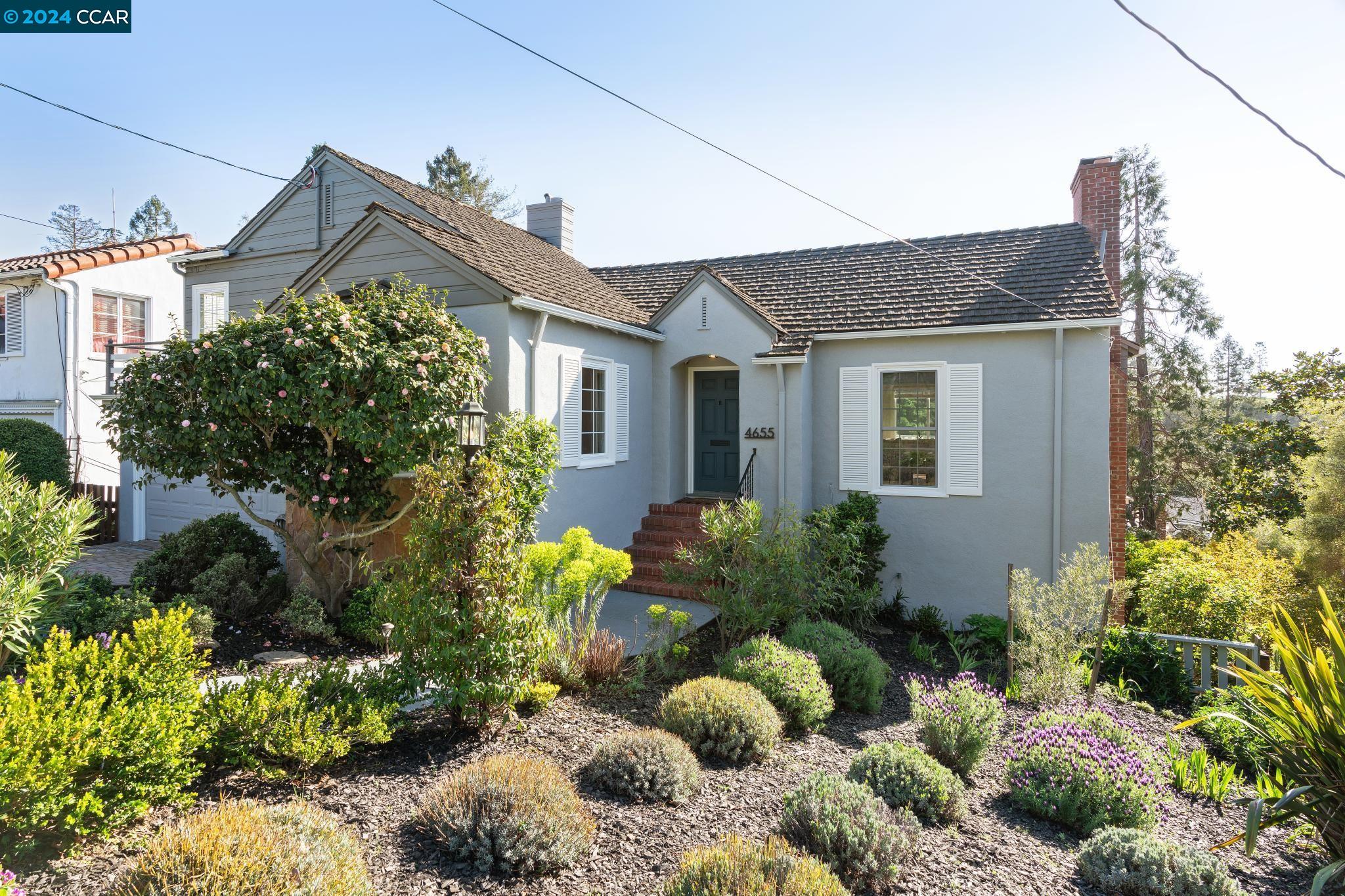 a front view of a house with a yard and a garden