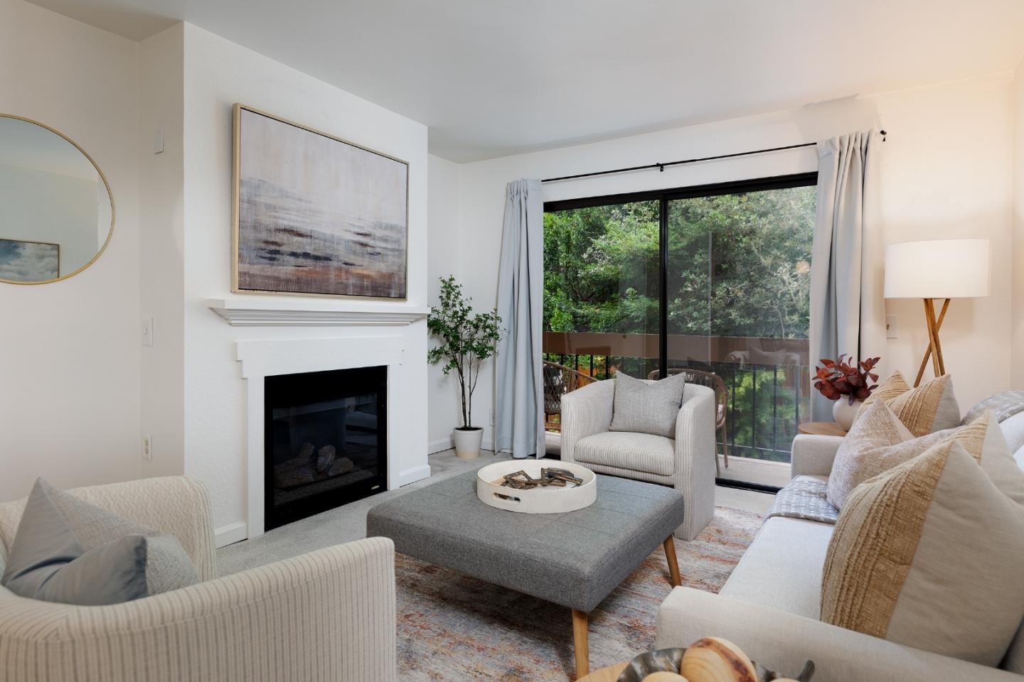 a living room with furniture a large window and a fireplace