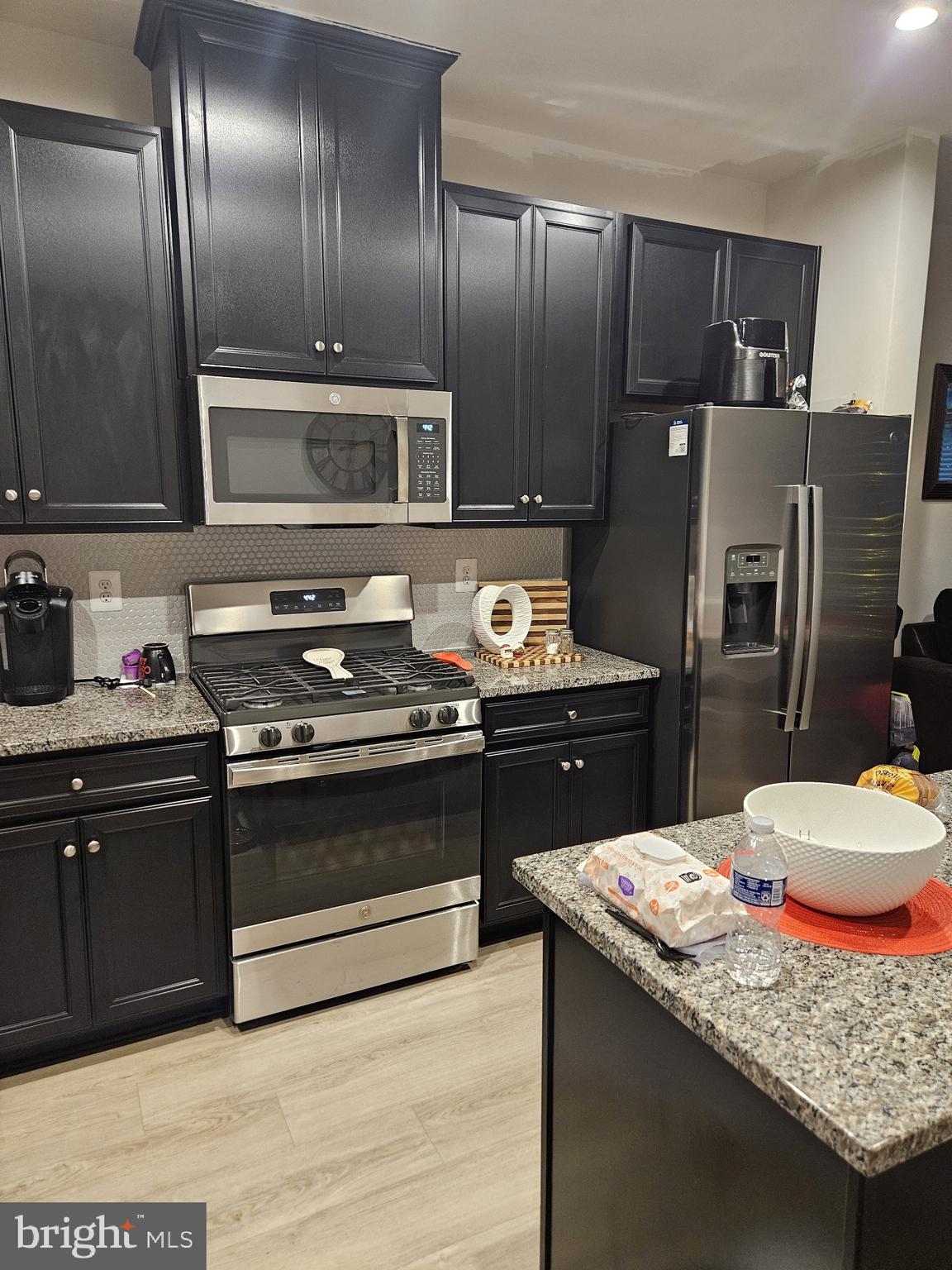 a kitchen with granite countertop stainless steel appliances and wooden cabinets