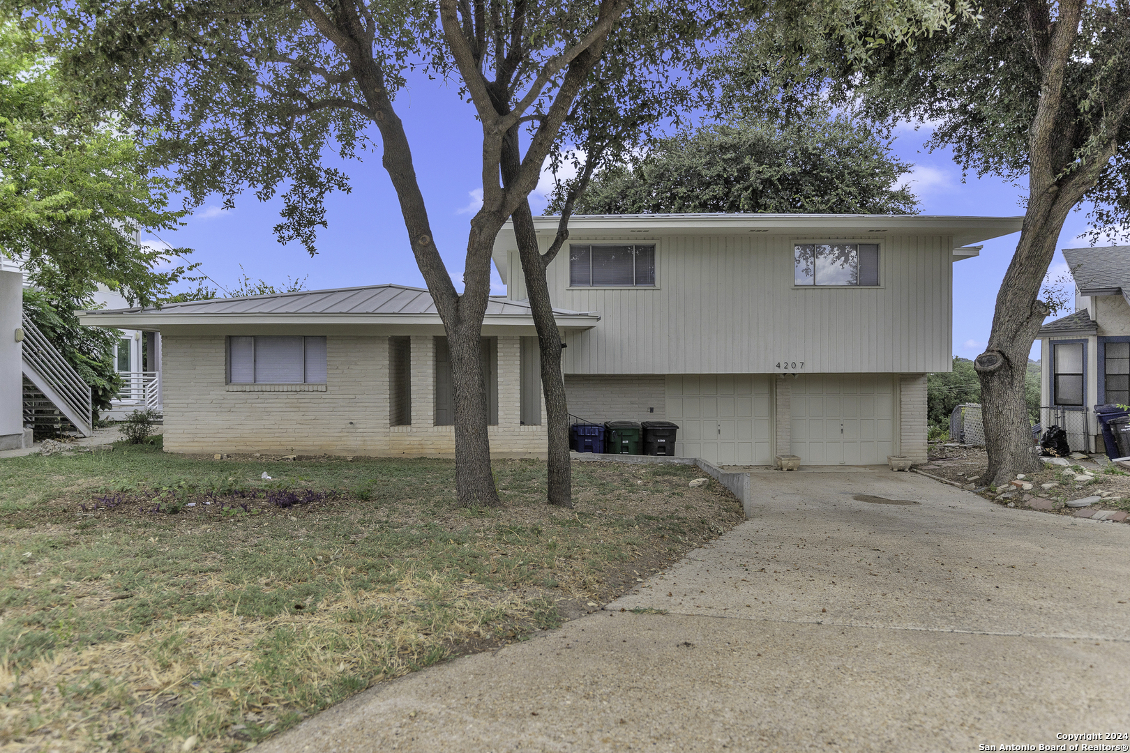 front view of a house with a large tree