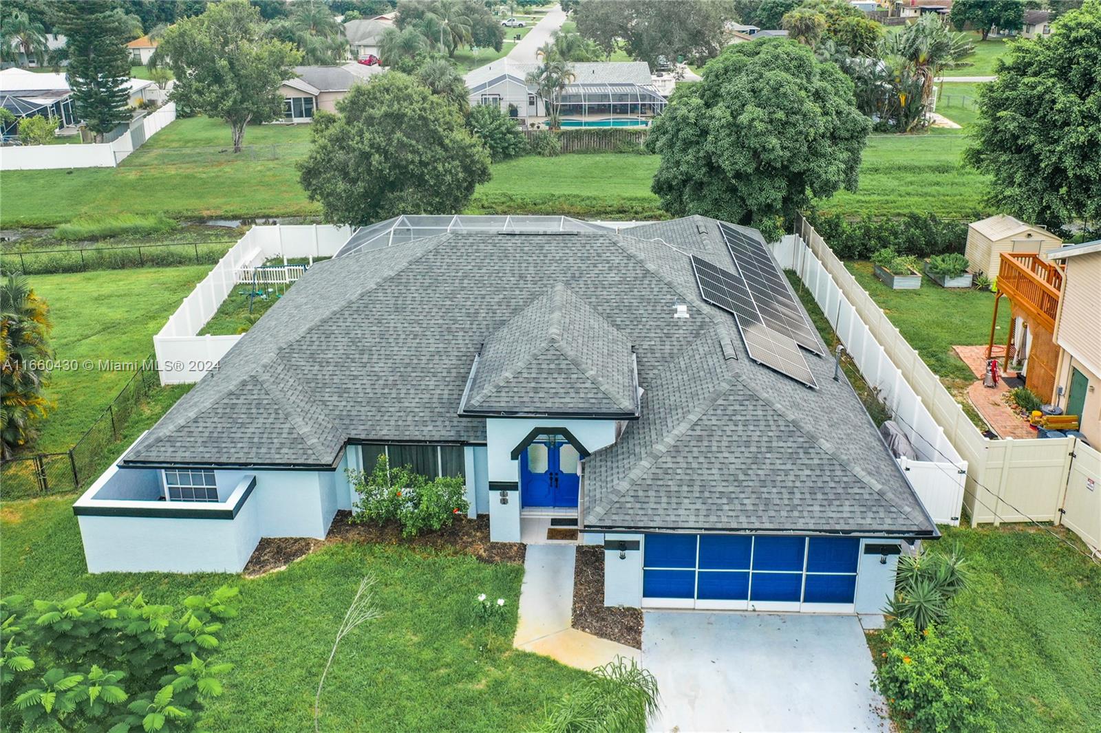 a aerial view of a house with a yard and large trees