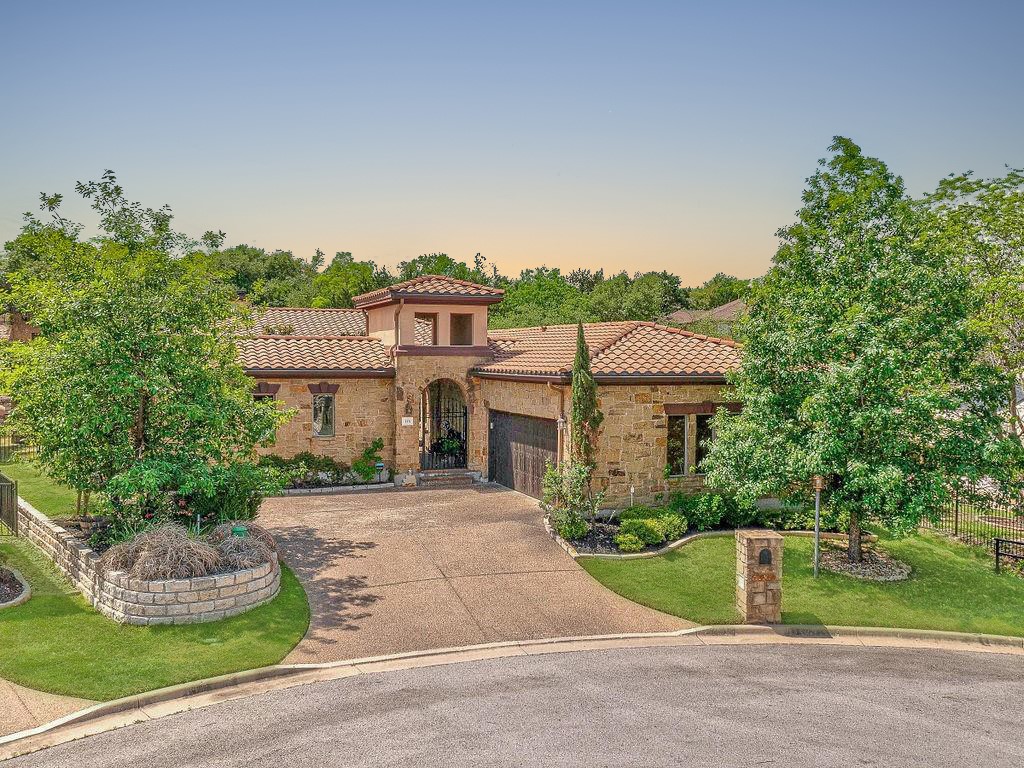 Tuscany or Lakeway? Nestled on a cul-de-sac & adorned with iron gates and stone arches that lead into a private courtyard.