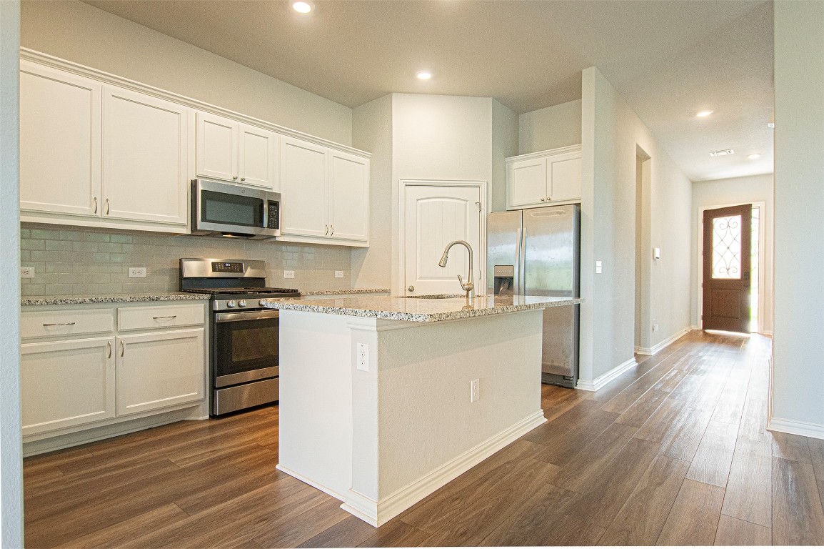 beautiful lighting in this living/ dinning/ kitchen open concept. 10 ft ceilings, breakfast bar, granite countertops