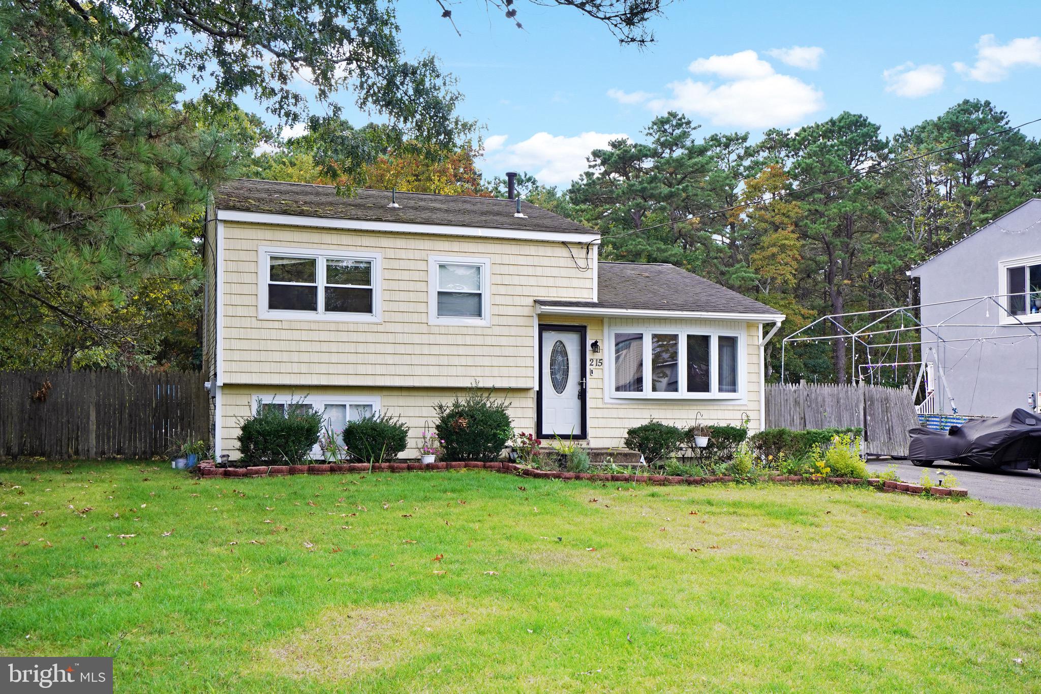 a front view of a house with a yard and trees