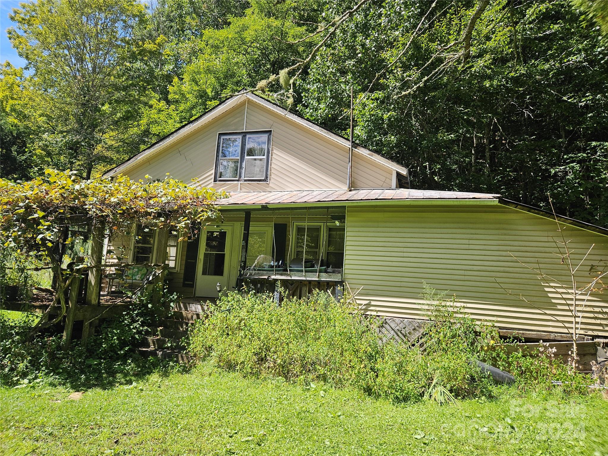 a front view of house with yard and trees around