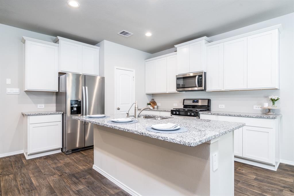 Gorgeous kitchen with white cabinets, granite counter tops, and stainless steel appliances
