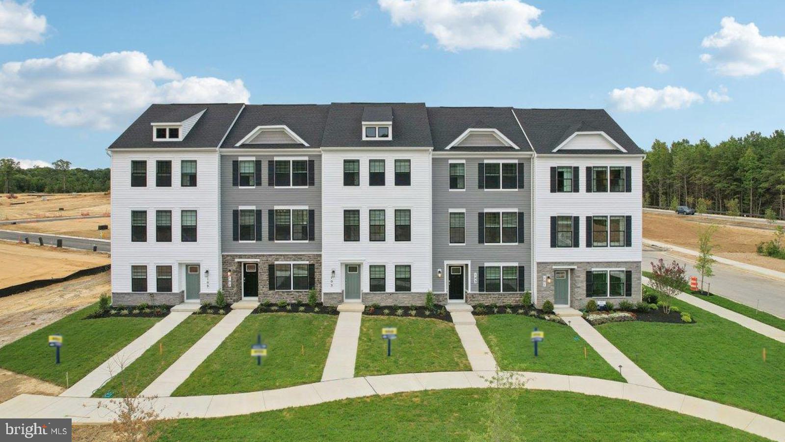 a front view of residential houses with yard and green space