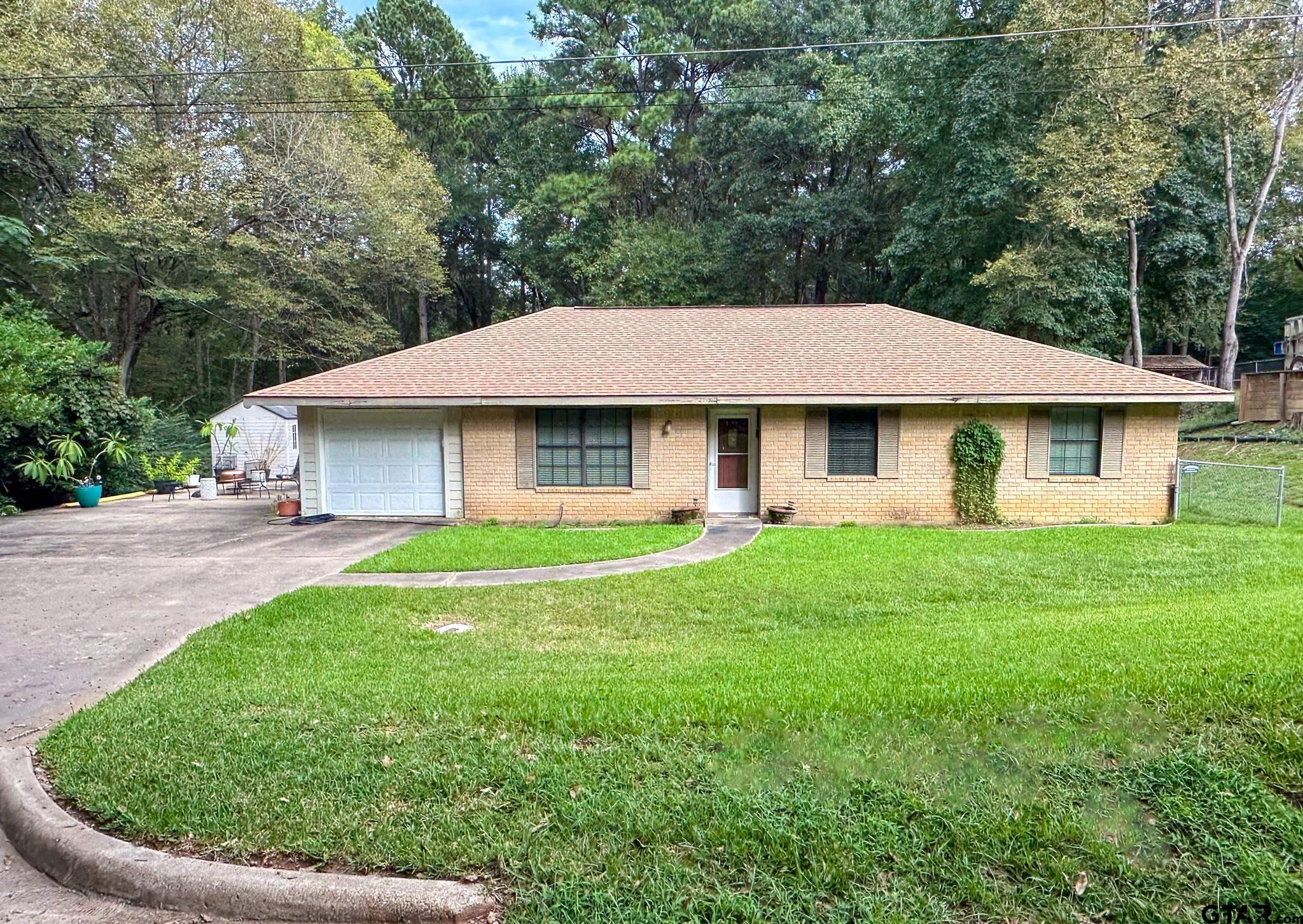 a view of a house with a yard and trees