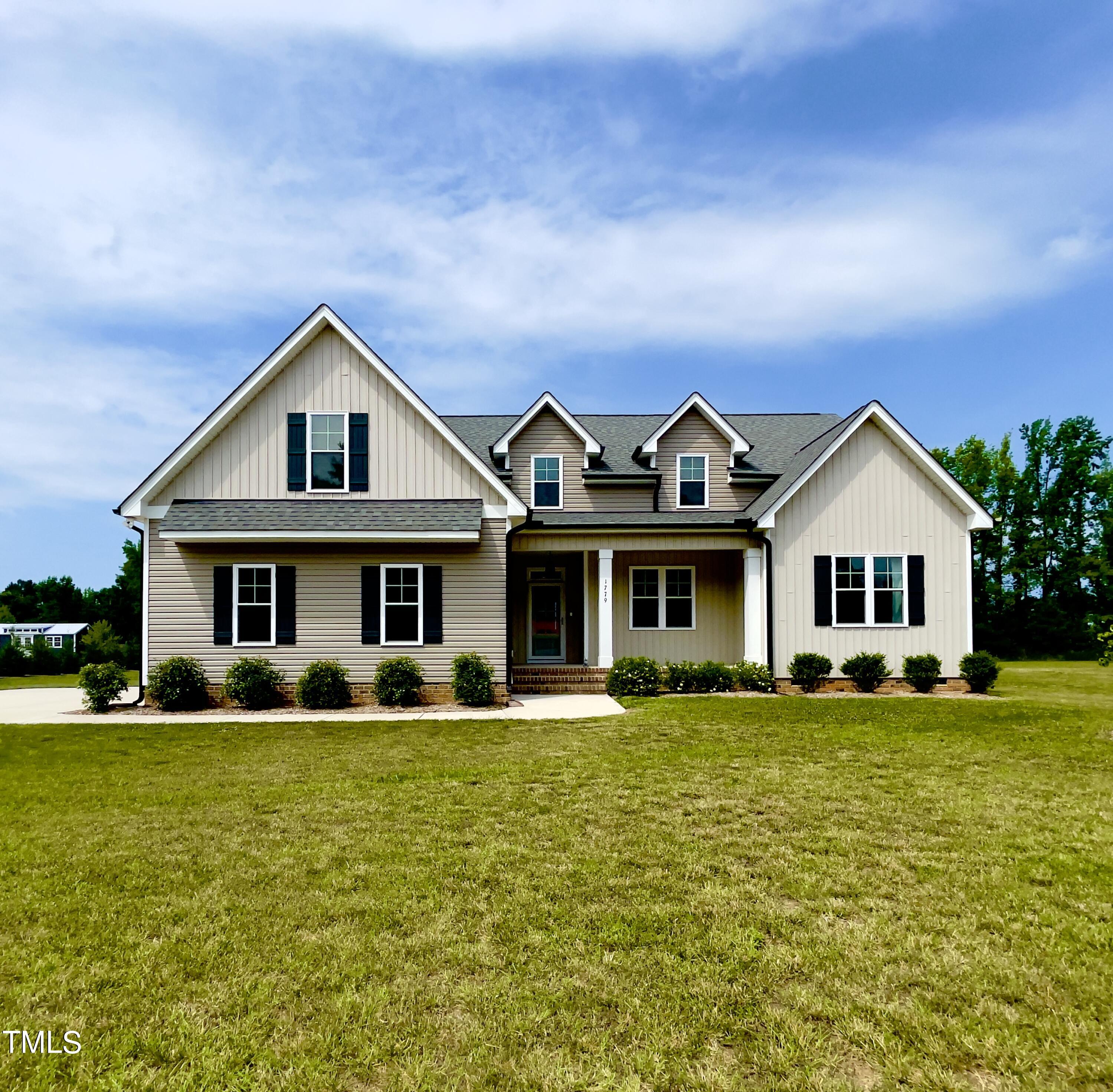 a front view of a house with a yard and trees