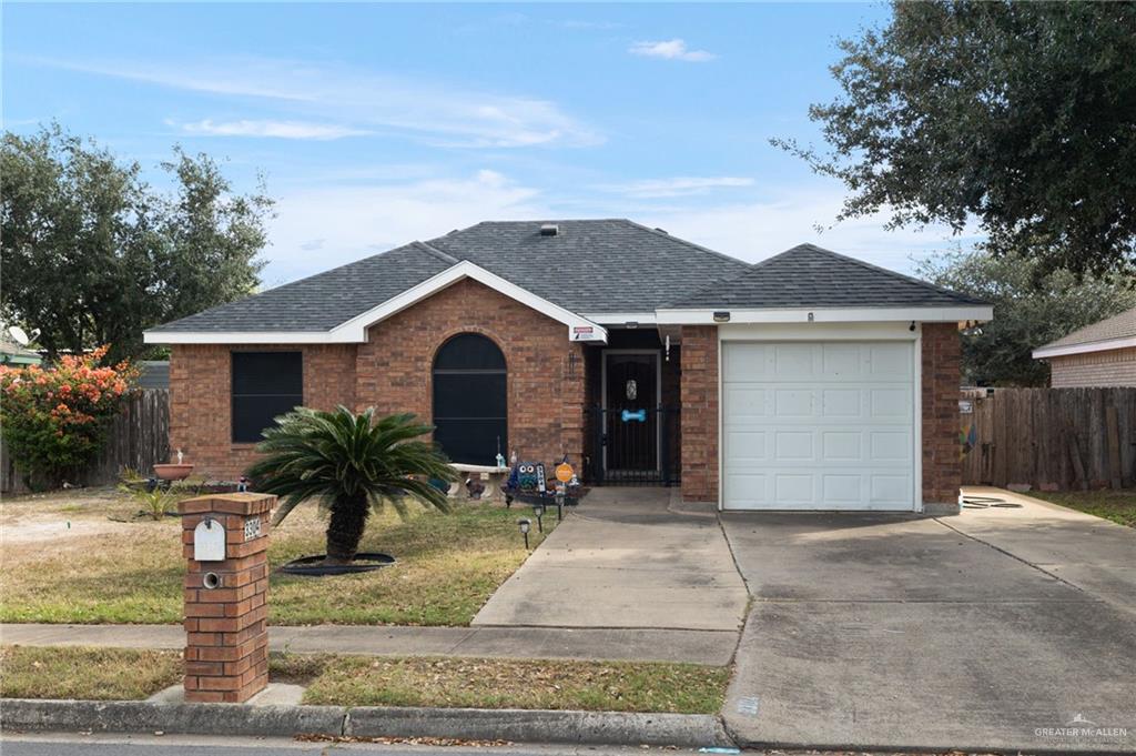 Single story home with a garage and a front lawn