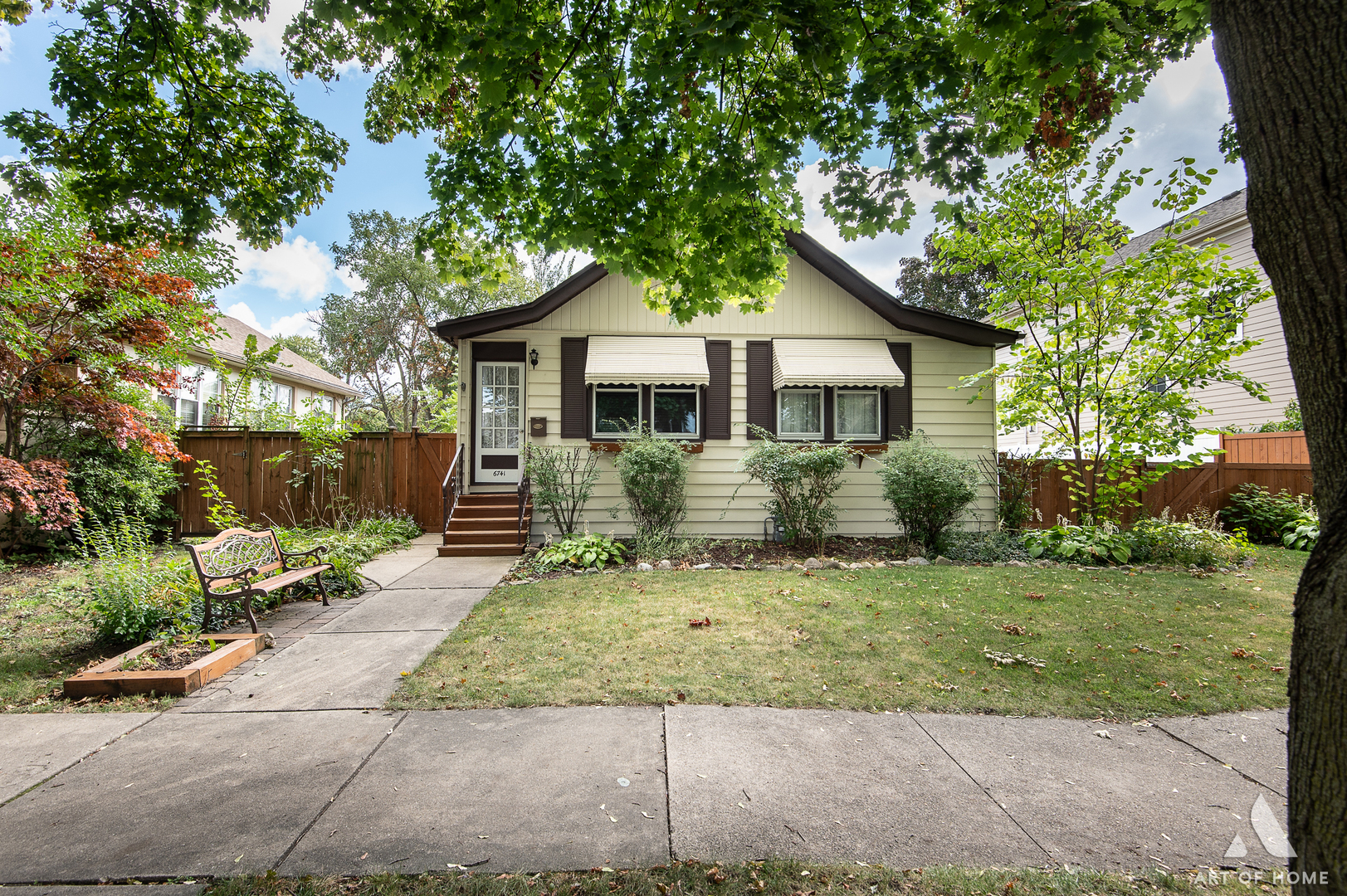 a view of a house with a yard and large tree