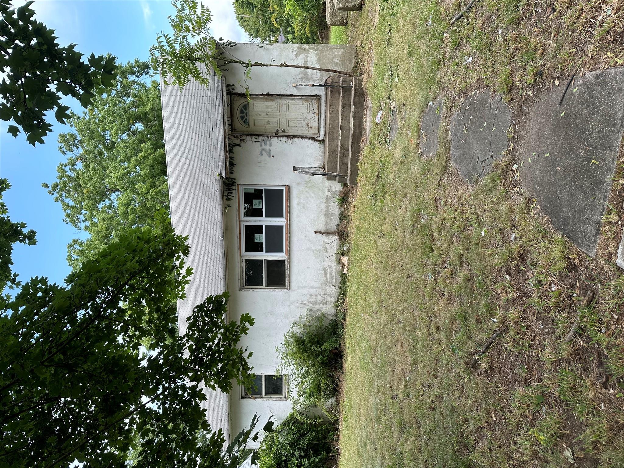 a front view of house with yard and trees around