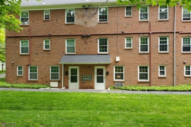 front view of a brick house with a yard