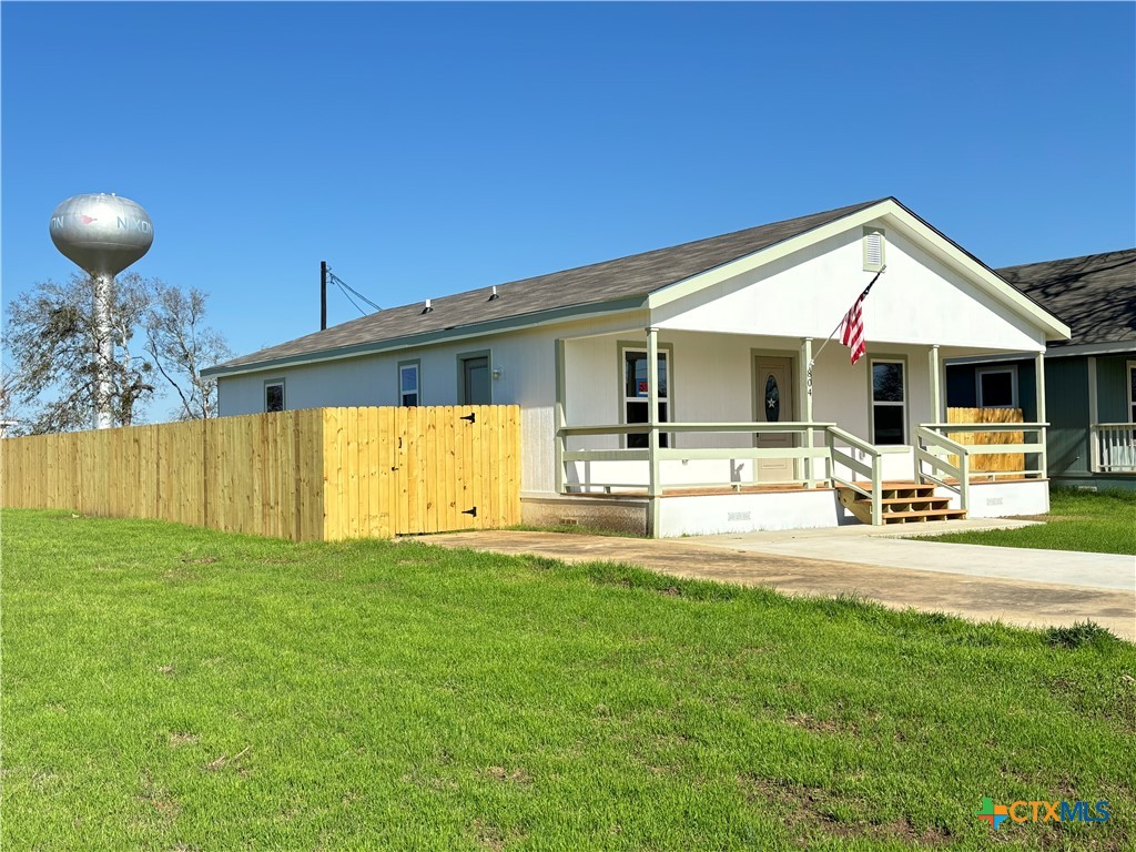 a front view of a house with swimming pool and furniture