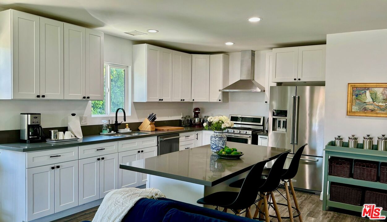 a kitchen with stainless steel appliances granite countertop a refrigerator sink and cabinets