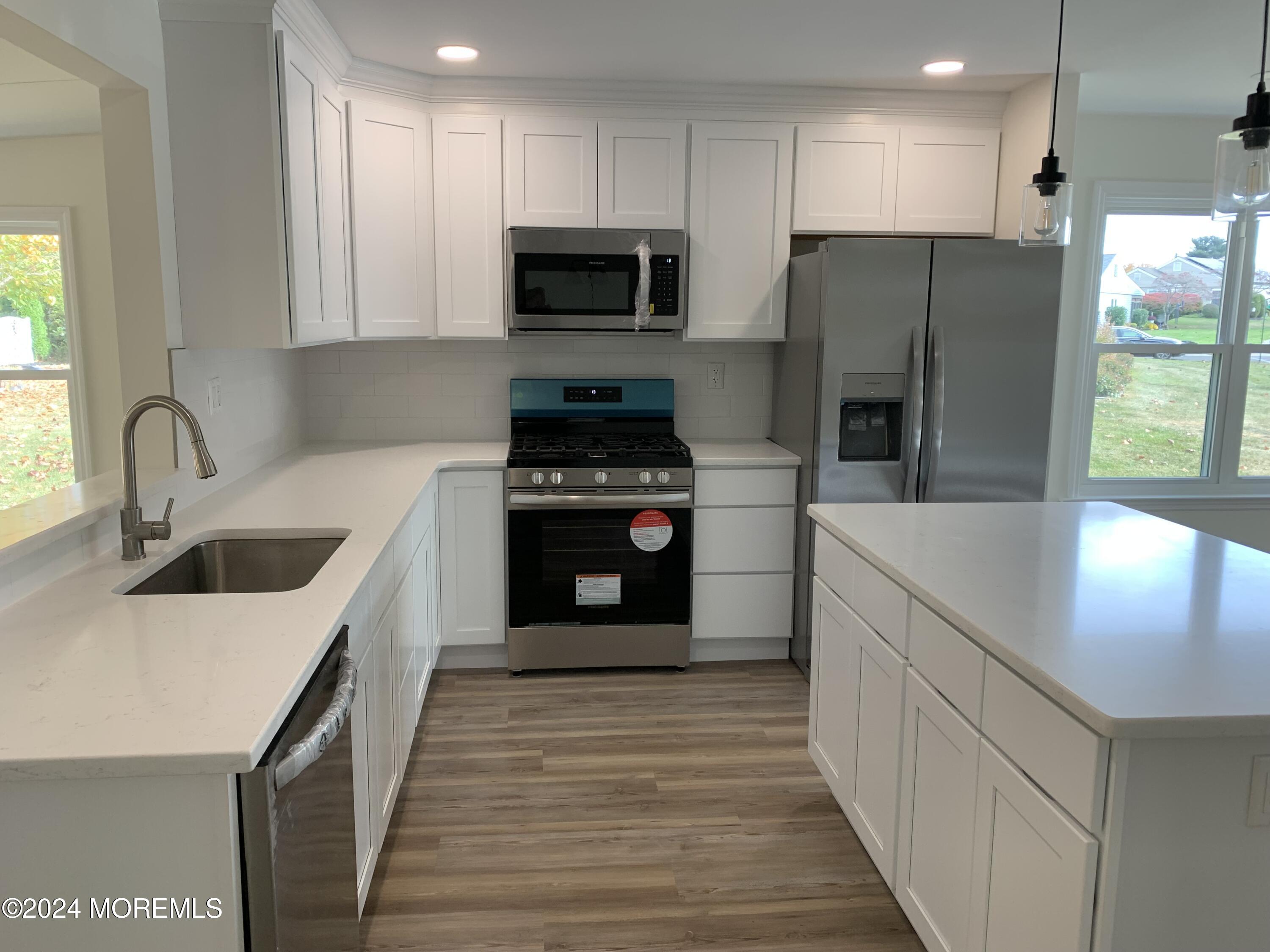 a kitchen with a refrigerator sink and wooden cabinets