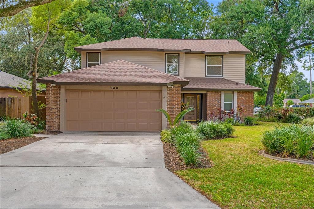 a front view of a house with a yard and trees