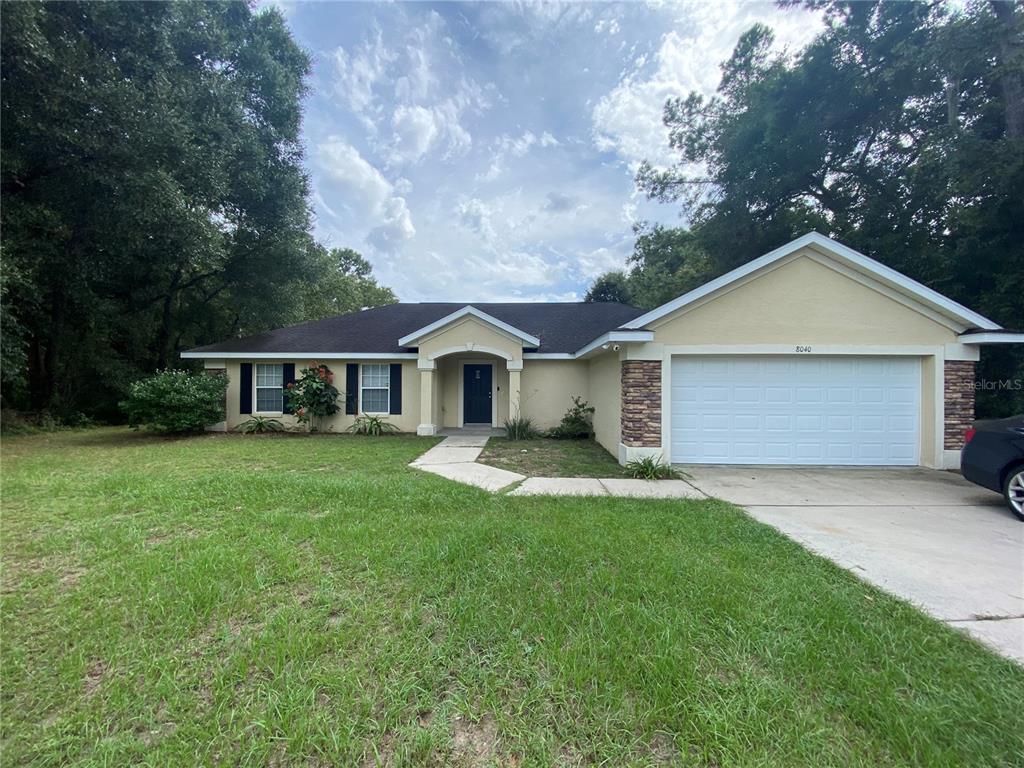 a front view of a house with a yard and trees