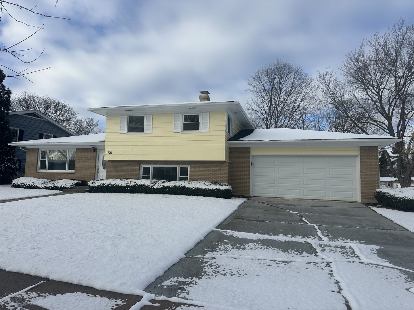 a front view of a house with yard and parking