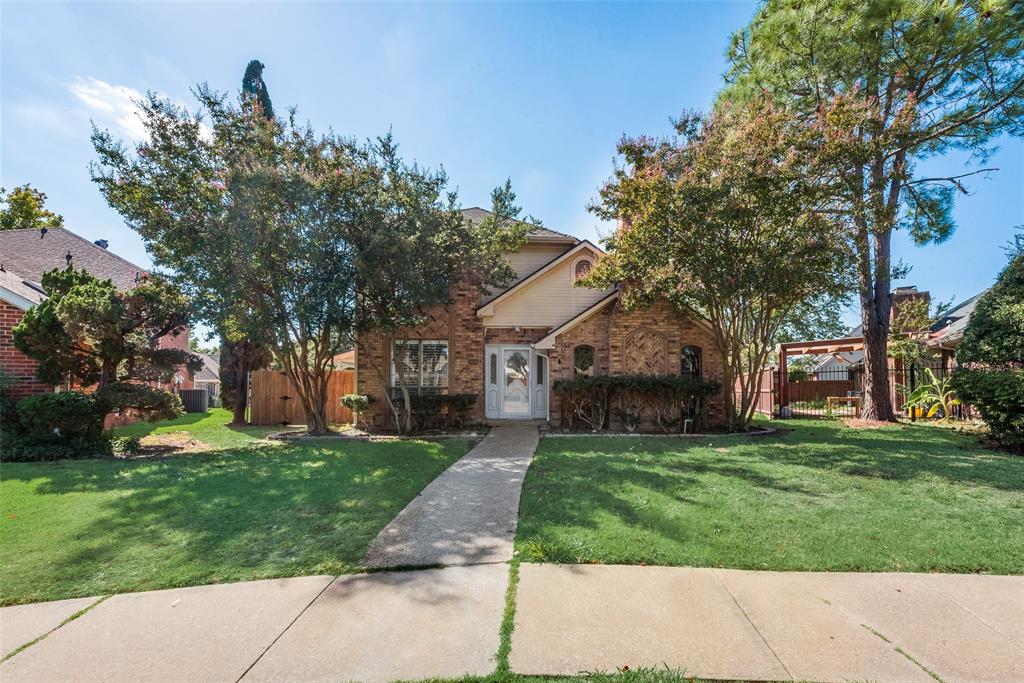 a front view of a house with a yard and trees