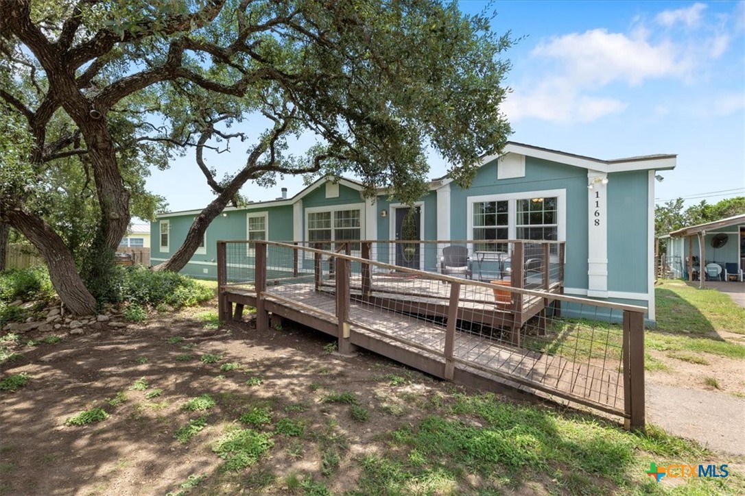 a view of a house with backyard wooden floor and wooden fence