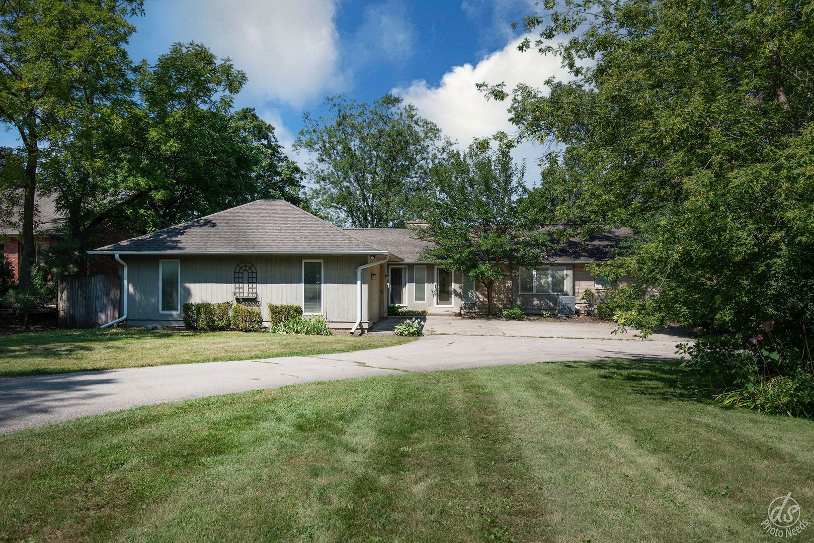 a front view of a house with a yard and trees