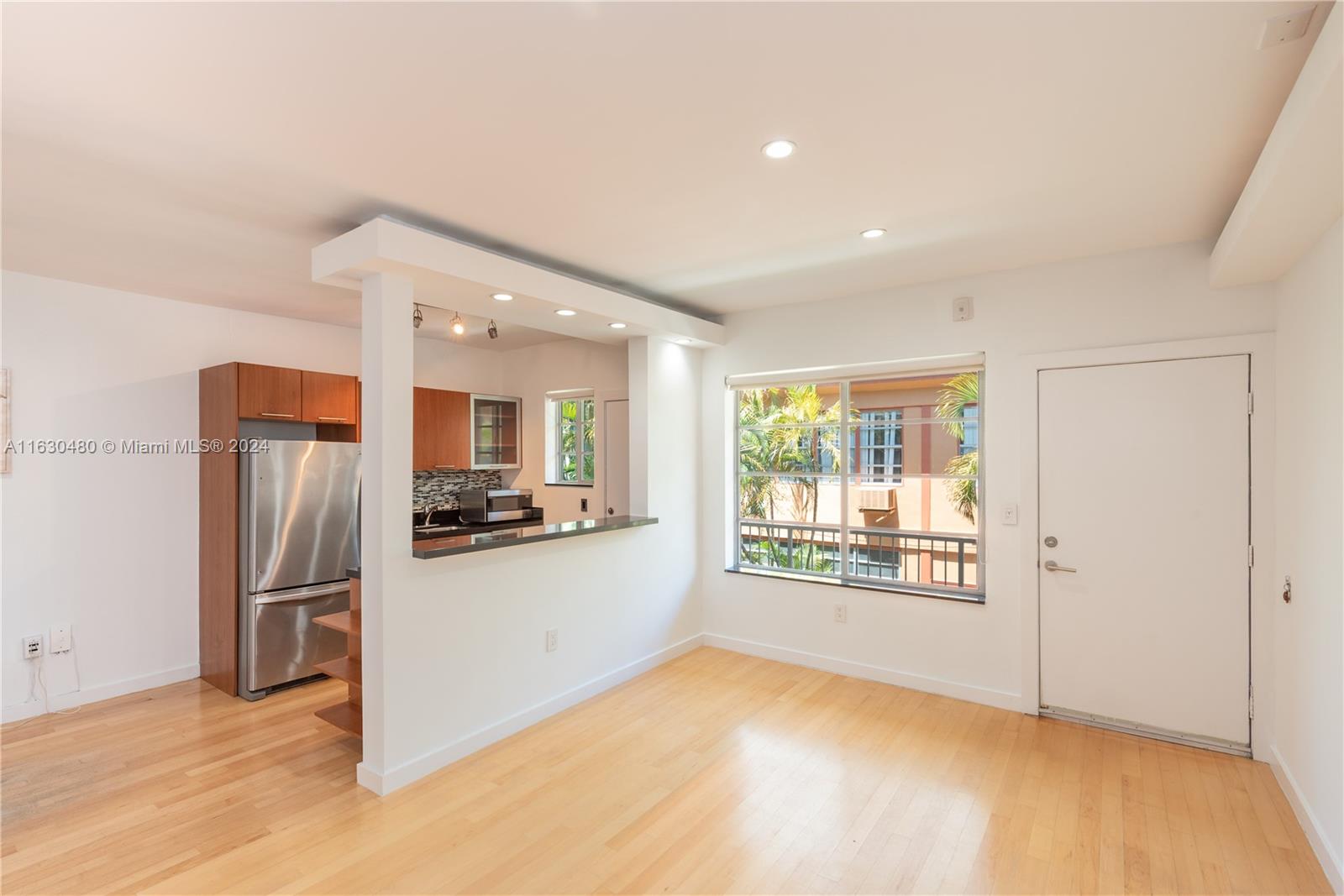 a view of a kitchen with a sink refrigerator and a window