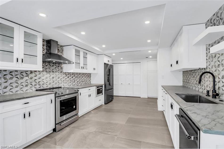 a kitchen with stainless steel appliances granite countertop a sink stove and cabinets