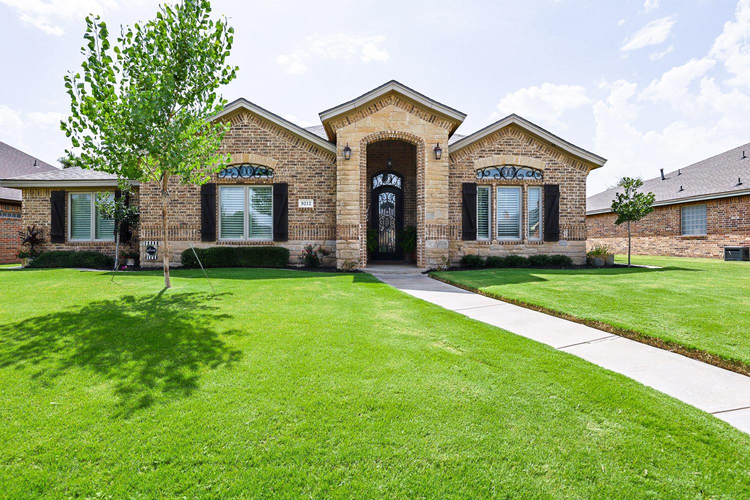 a front view of a house with yard and green space