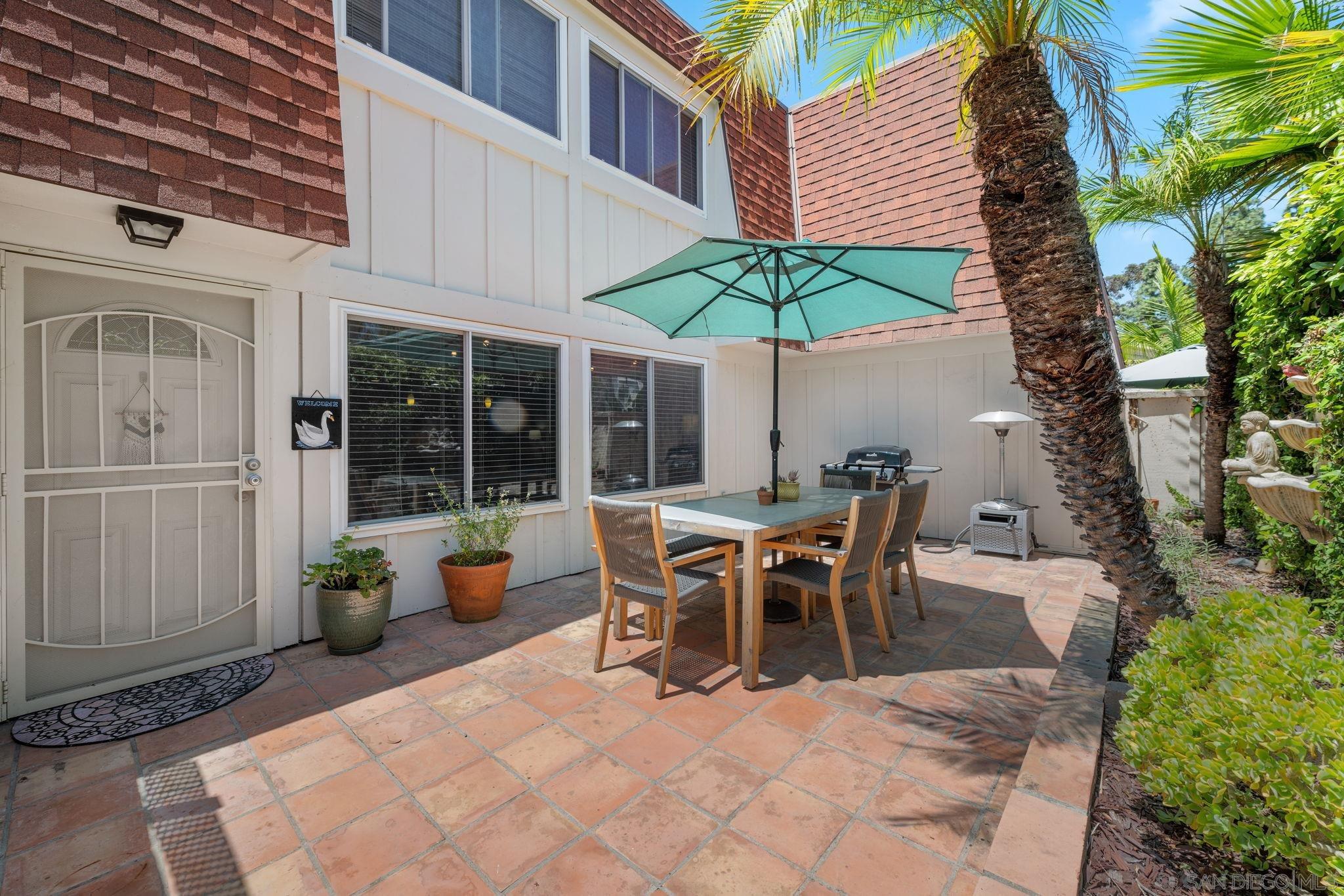 a view of a patio with table and chairs under an umbrella