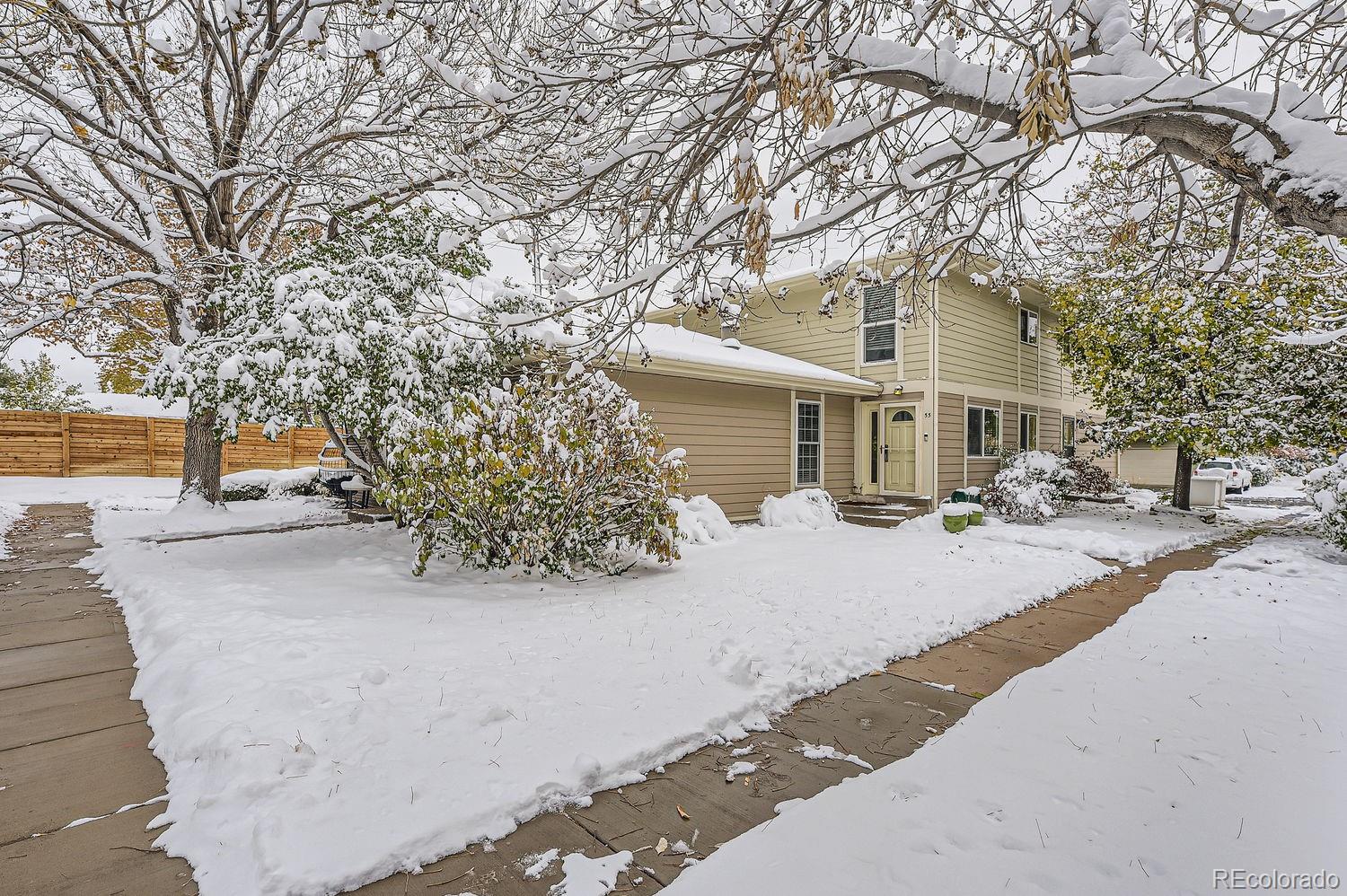 a front view of a house with a yard and tree s