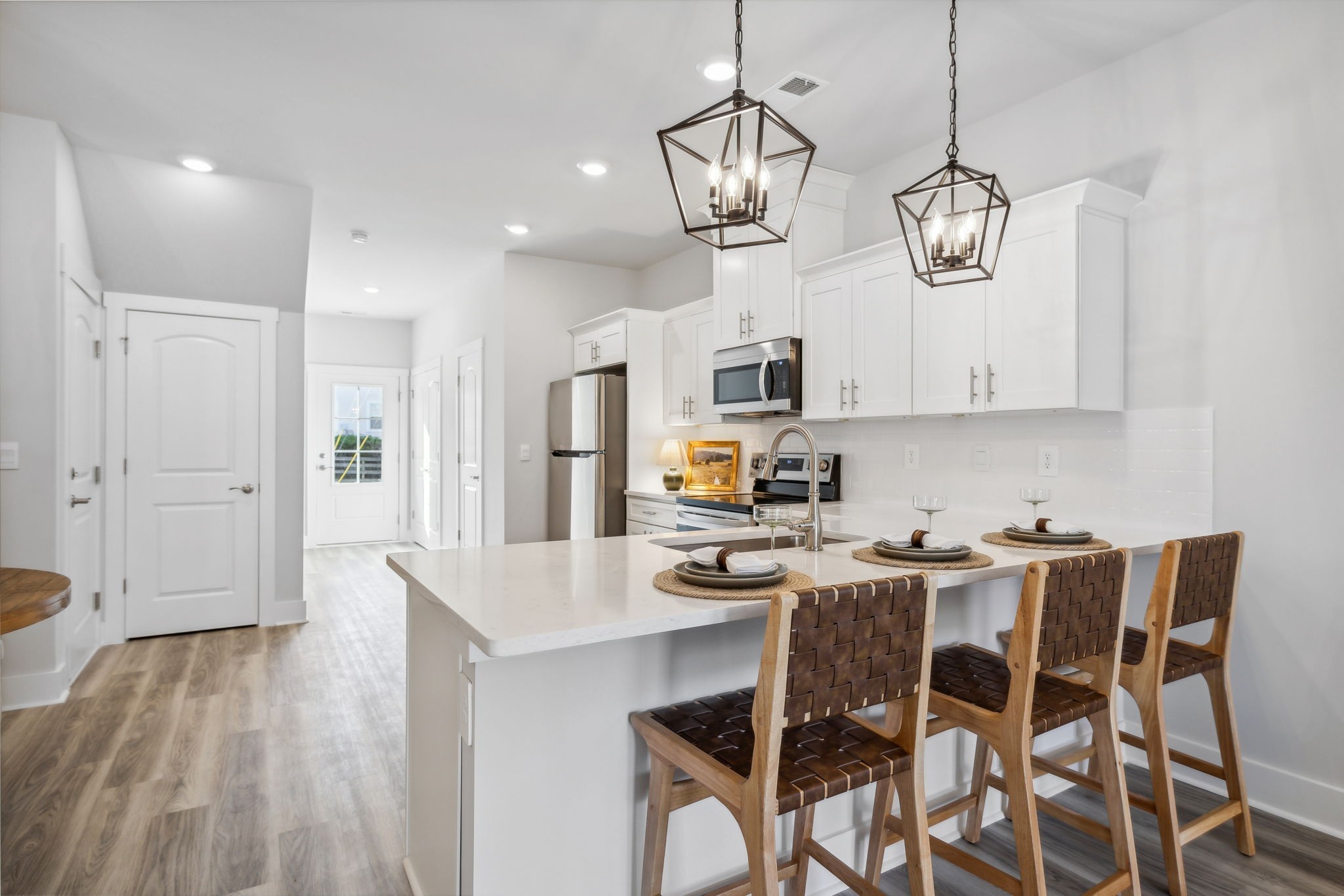 a view of dining table chairs wooden floor and kitchen