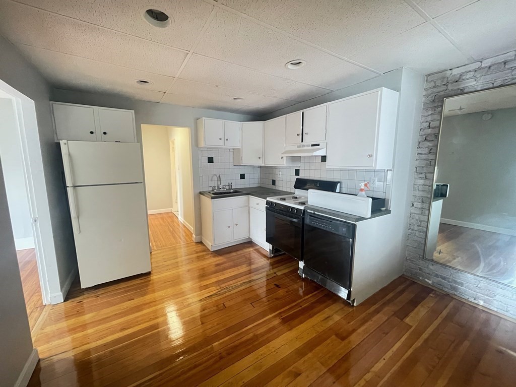 a kitchen with a refrigerator a stove top oven a sink and cabinets