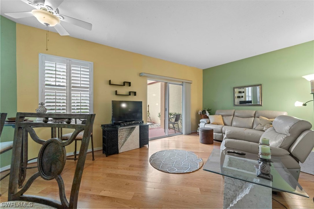 a living room with furniture a dining table and chairs with wooden floor