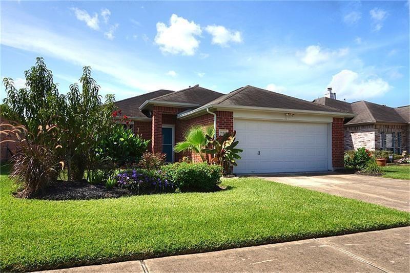 a front view of a house with a garden and yard