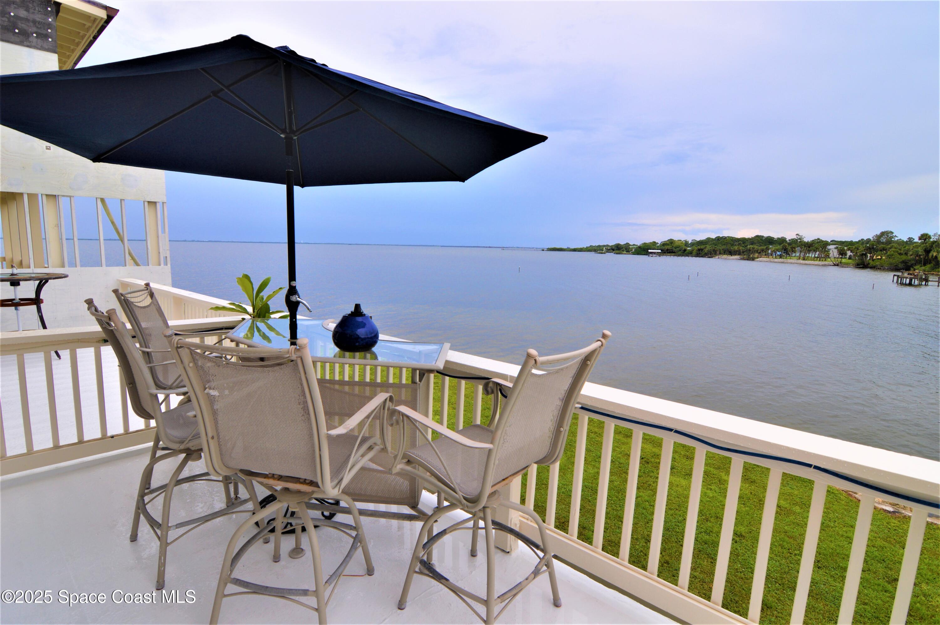 a view of balcony with furniture and umbrella