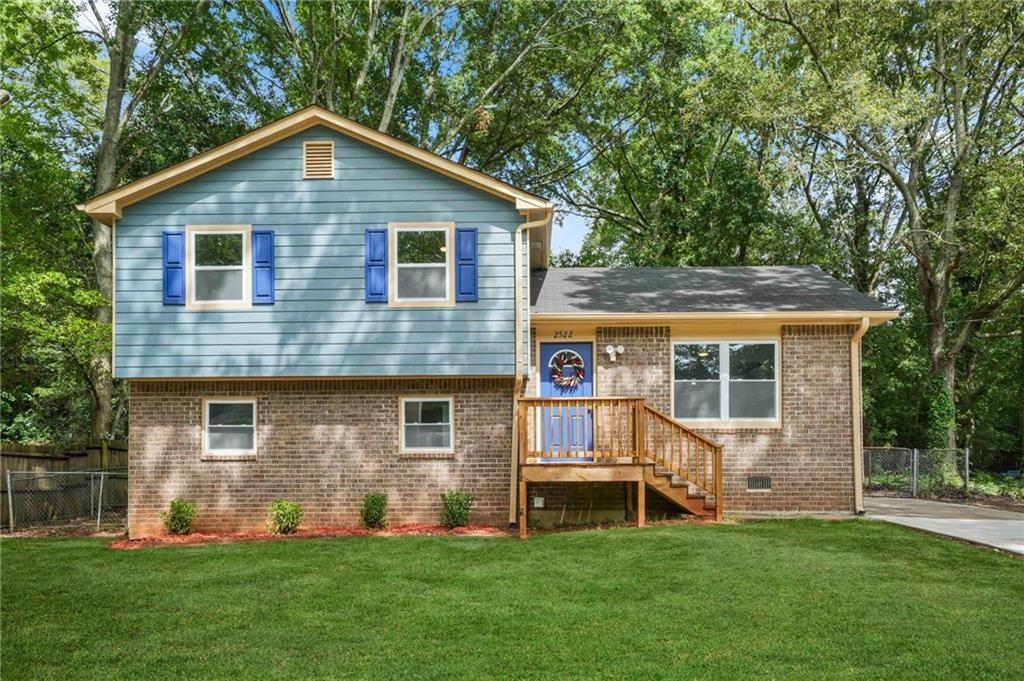 a front view of a house with a yard and fence