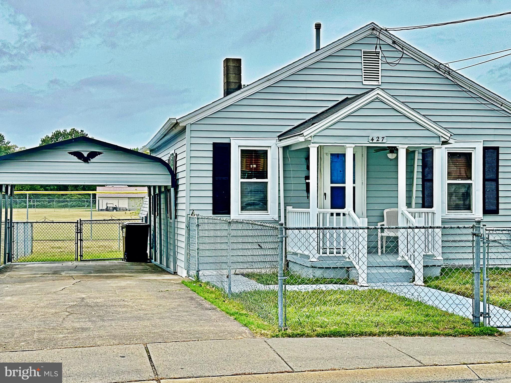 a view of a house with a small yard and wooden fence