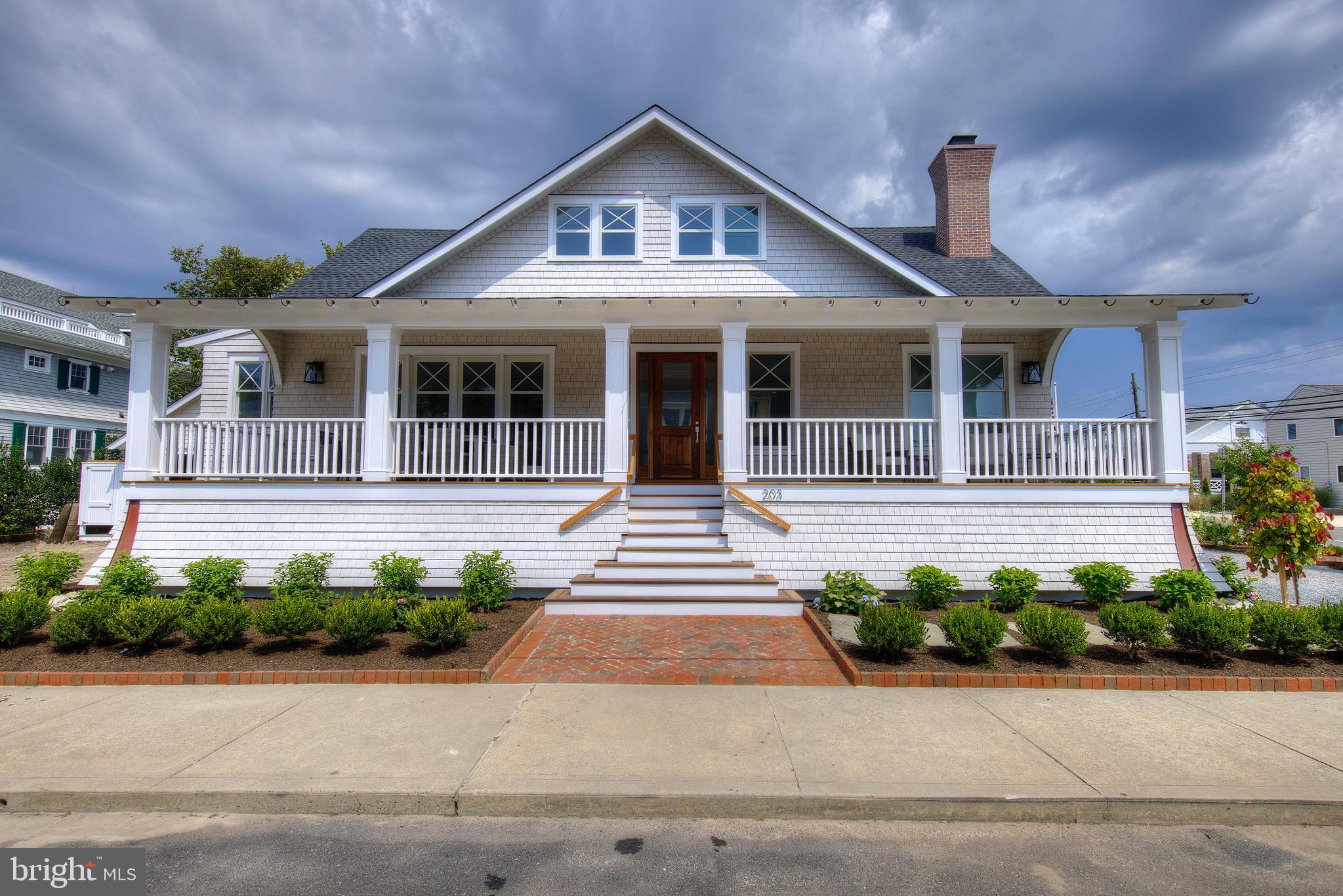 a front view of a house with a yard and potted plants