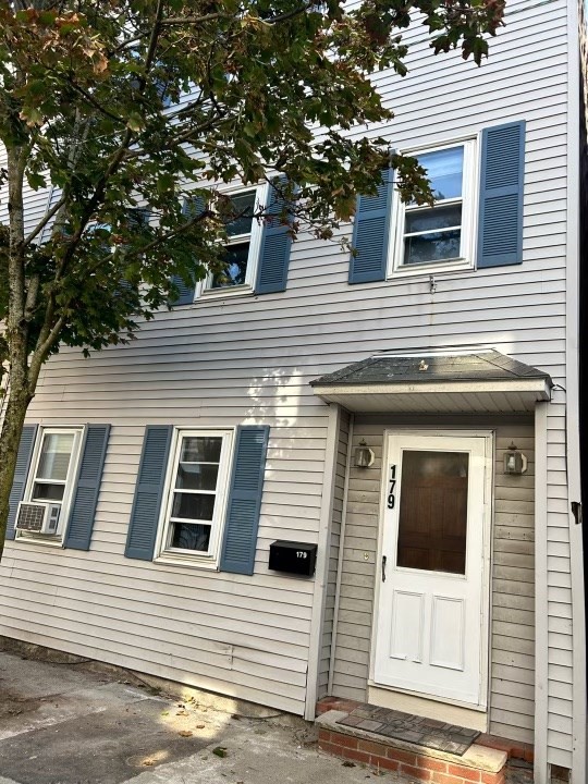 a view of a house with a door and a tree