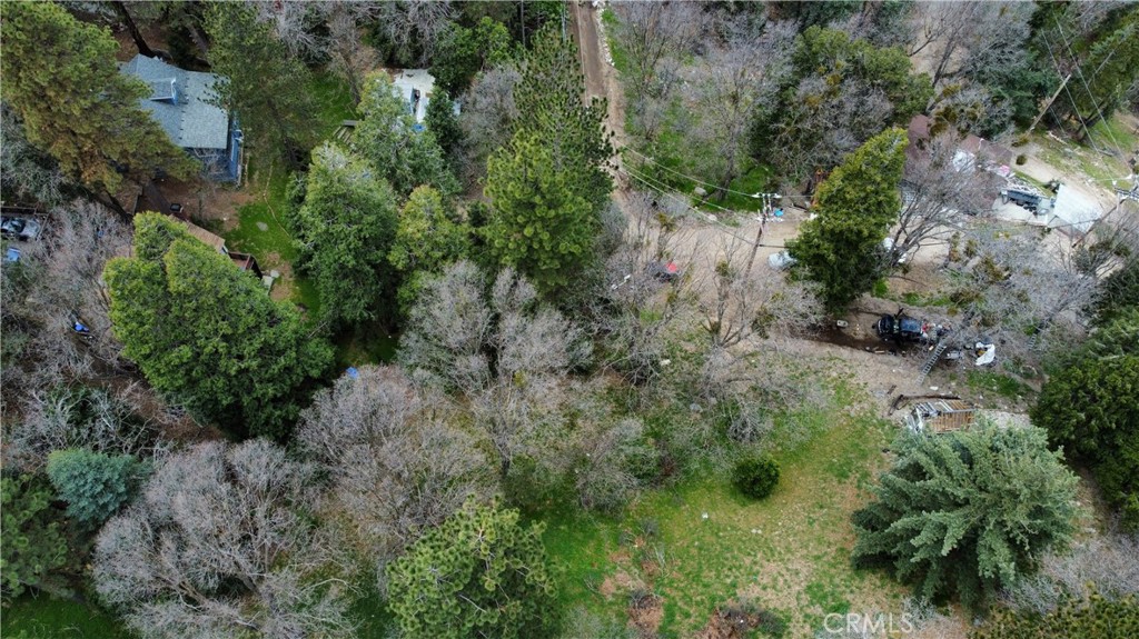 an aerial view of residential house with outdoor space and trees all around