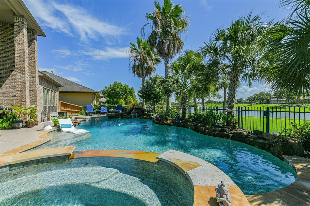 a swimming pool with barbeque oven outdoor seating and yard