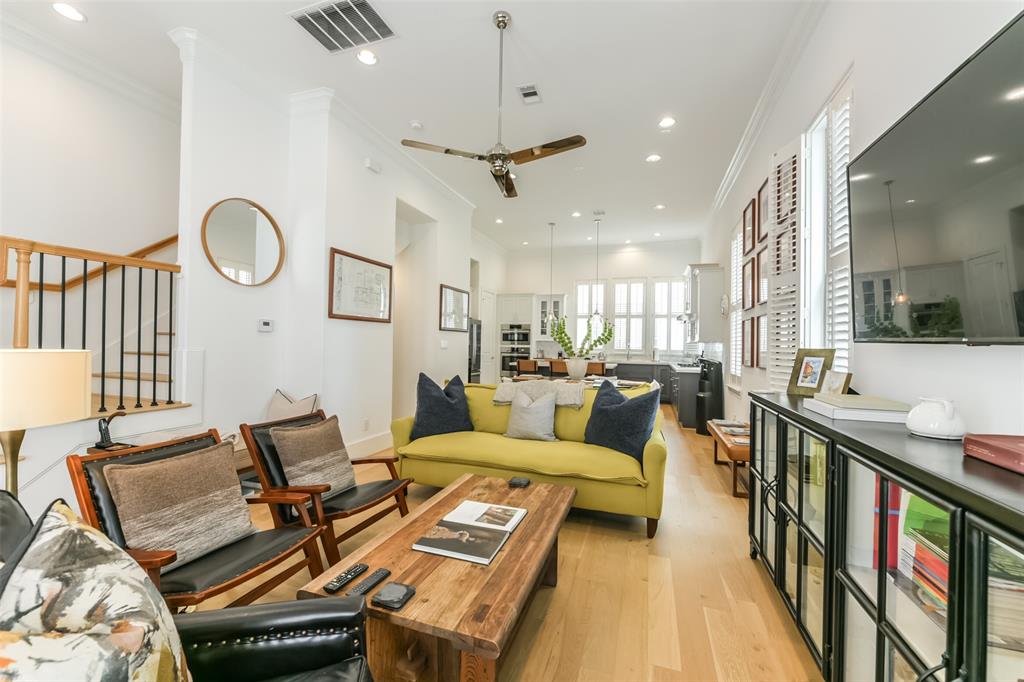 a living room with furniture kitchen view and a chandelier